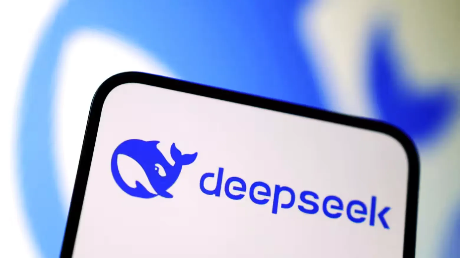 Close-up of a smartphone displaying the DeepSeek logo: a blue whale and the company name in blue text on a white background.