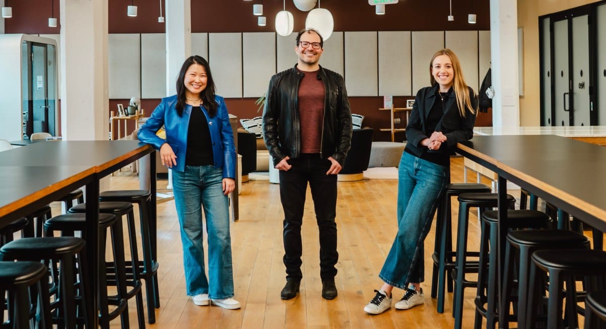 Partovi and his two partners at Neo, Suzanne Xie and Emily Cohen., stand in a modern office, smiling at the camera. Two women flank a man in the center.