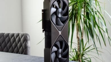 Nvidia RTX 5080 graphics card stands upright on a table, showcasing its dual fans and sleek design.