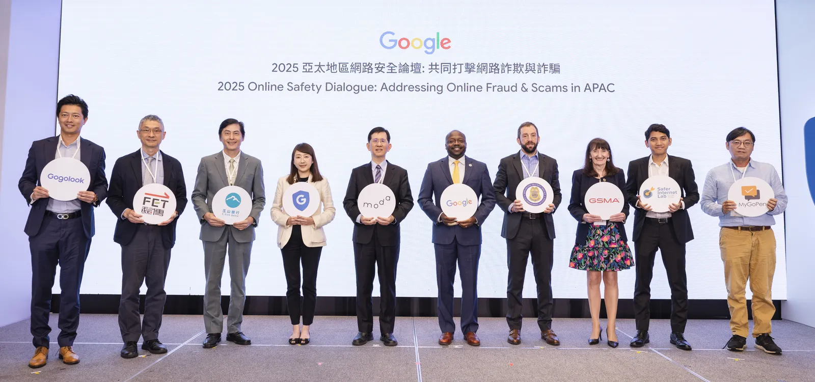 Ten individuals hold company logos at the 2025 Online Safety Dialogue in APAC, addressing online fraud and scams.
