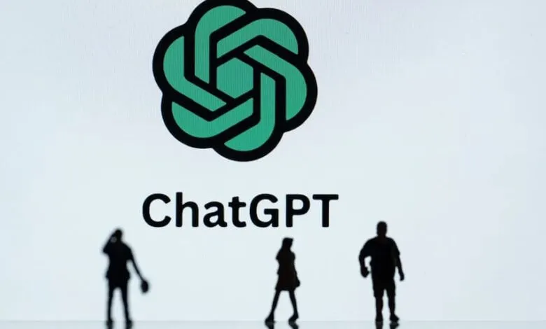 ChatGPT logo on a screen with three small, dark silhouettes of people in front.