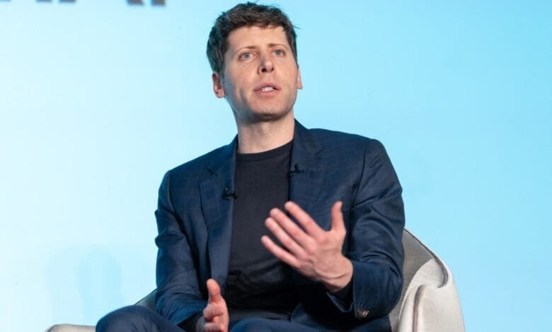 Sam Altman, A man in a dark blue blazer gestures while speaking at a conference.