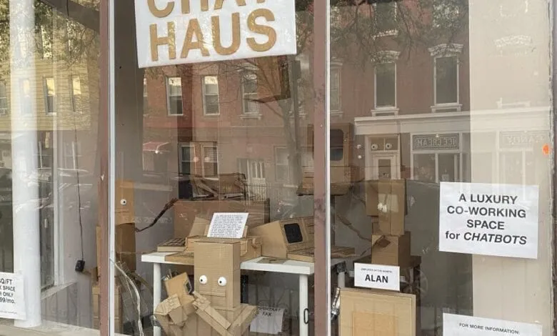 Cardboard chatbot figures in a storefront window display for Chat Haus, a co-working space.