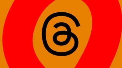 Abstract graphic with a large black '@' symbol centered on an orange background, surrounded by red and orange concentric circles.