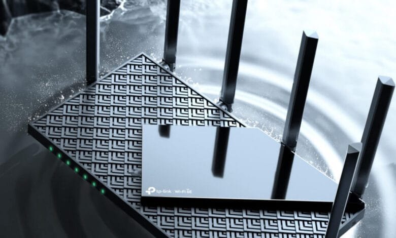 A sleek, black TP-Link Archer AXE75 Wi-Fi 6E router with four antennas, partially submerged in water, showcasing its water-resistant design.