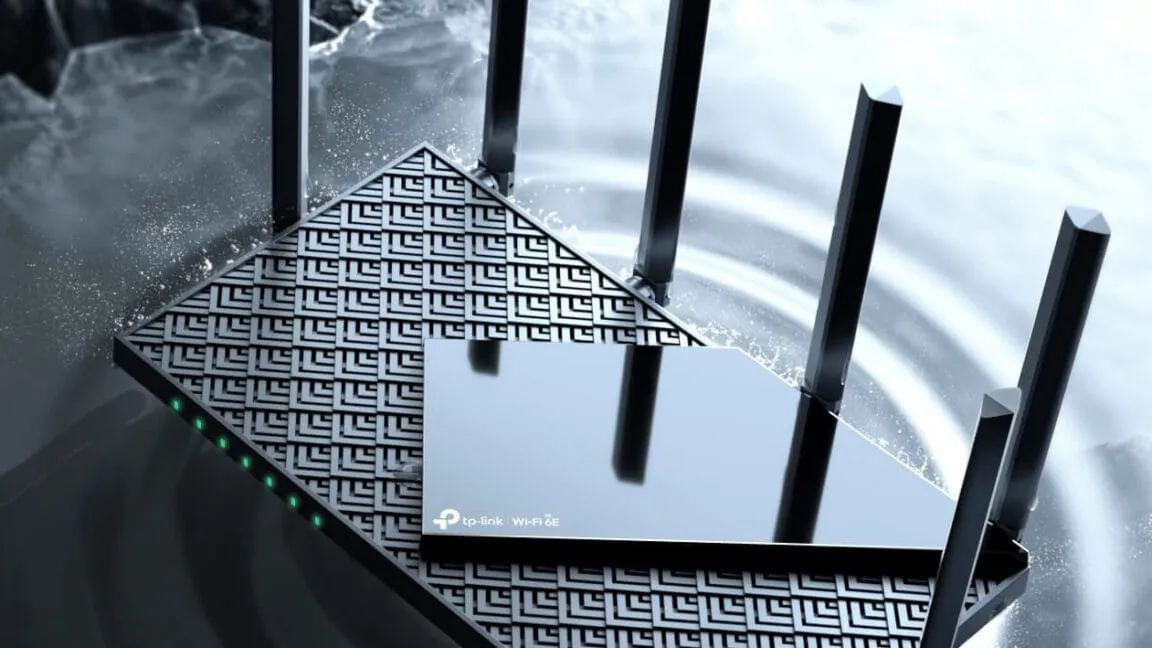 A sleek, black TP-Link Archer AXE75 Wi-Fi 6E router with four antennas, partially submerged in water, showcasing its water-resistant design.