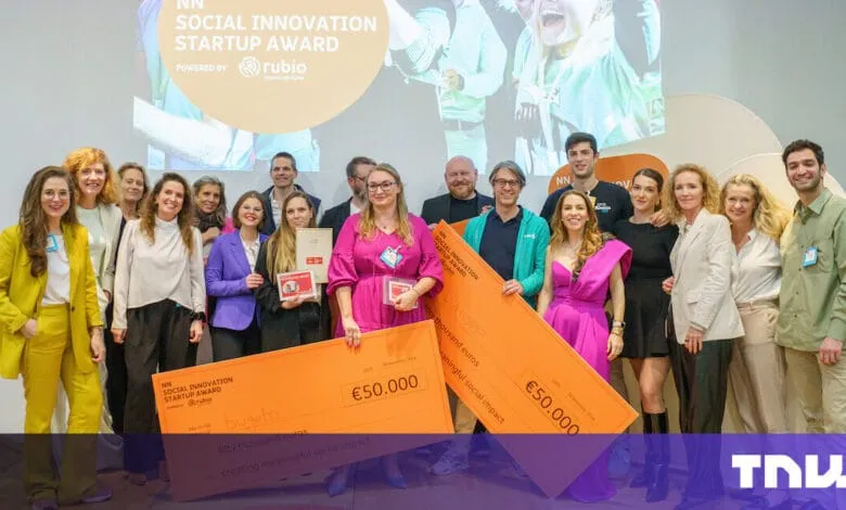 Winners of the NN Social Innovation Startup Award pose with oversized €50,000 checks. A diverse group celebrates their achievement.