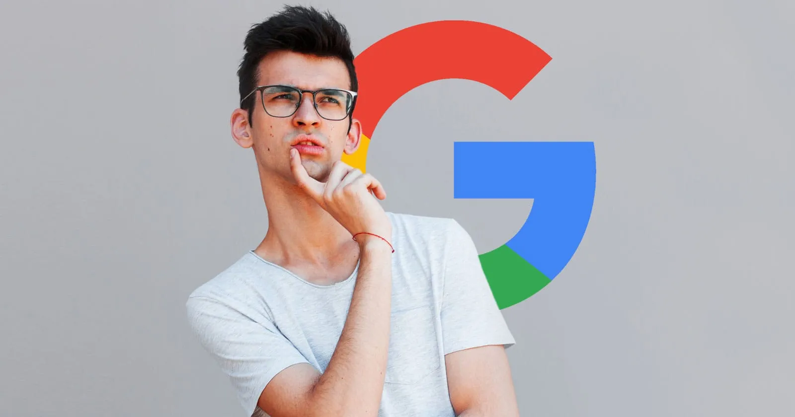 A young man wearing glasses thoughtfully touches his chin, with a large Google logo behind him.