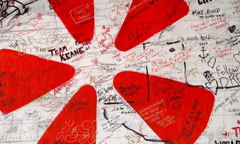 A world map covered in red handprints and various handwritten messages, signatures, and drawings.