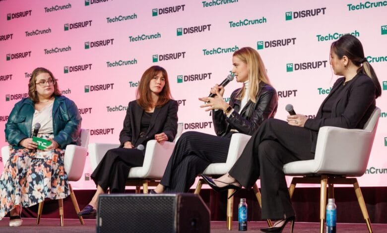 Four women sit on stage at a TechCrunch Disrupt event, participating in a panel discussion.