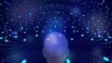 Abstract digital art depicting a head formed from glowing particles, with more particles radiating outwards.