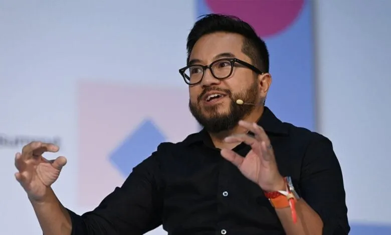 A man with glasses, Garry Tan, and a beard speaks passionately, gesturing with his hands. He's wearing a black shirt and a wristband.