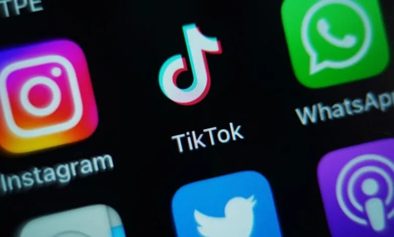 Close-up of smartphone screen showing TikTok, Instagram, Twitter, and WhatsApp app icons.