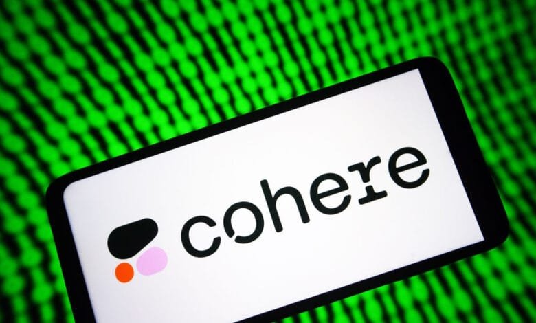 Cohere logo displayed on a smartphone screen against a blurred green background of code.