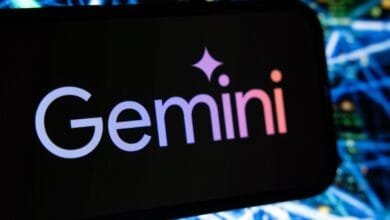 Gemini cryptocurrency exchange logo on a smartphone screen, with a blurred background of blue and green network cables.