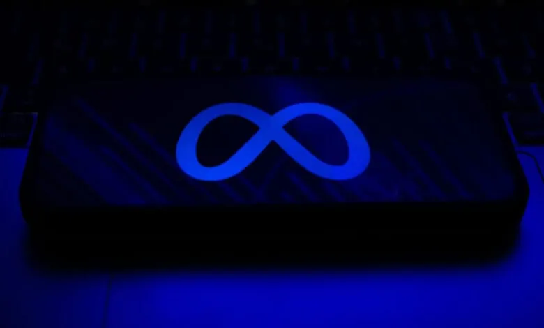 Close-up of a smartphone displaying Meta's blue infinity logo on a dark screen.