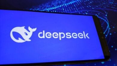 Close-up of a smartphone displaying the DeepSeek logo on a bright blue background.