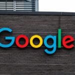 The colorful Google logo is displayed on a dark brick building.