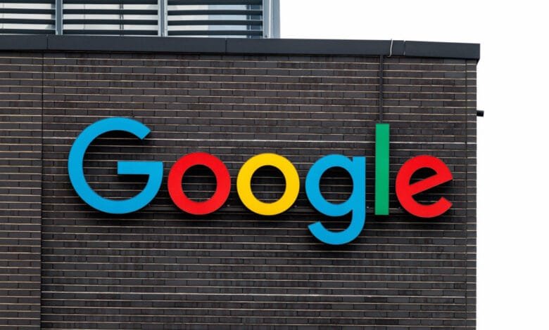 Google's colorful logo on a dark brick building.