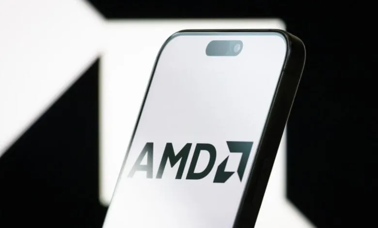 Close-up of a smartphone displaying the AMD logo on a bright white screen against a dark background.