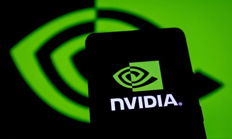 Close-up of a smartphone displaying the Nvidia logo, backlit by a green Nvidia logo projection.