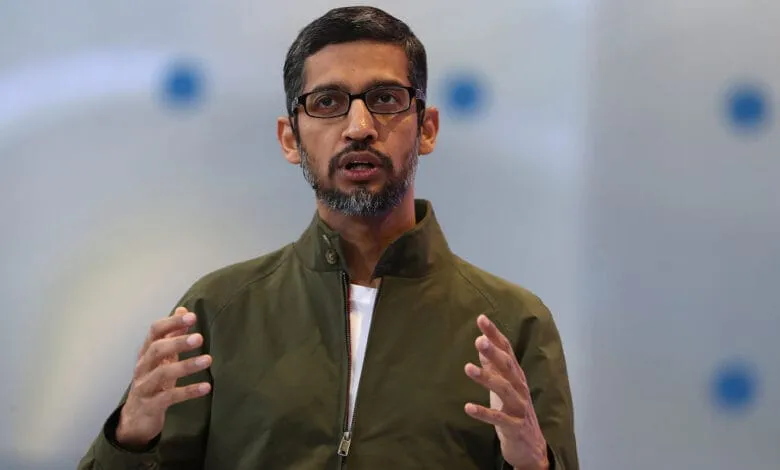 Sundar Pichai, Google CEO, speaks passionately, hands gesturing, wearing glasses and an olive green jacket.