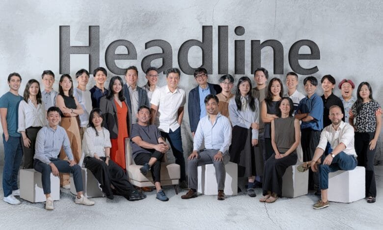 Headline team group photo: Diverse group of 25+ professionals pose in front of the word 'Headline'.