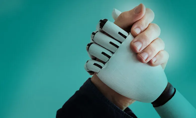 A human hand shakes a robotic hand against a teal background, symbolizing collaboration between humans and AI.