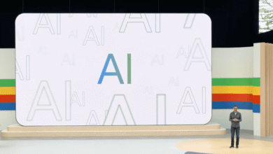 A large screen displays the letters AI repeatedly in various sizes and shades of blue and green, a person stands on a stage in front of it.