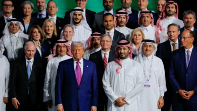 Donald Trump and Mohammed bin Salman stand together at a large investment forum, surrounded by other attendees in business attire.