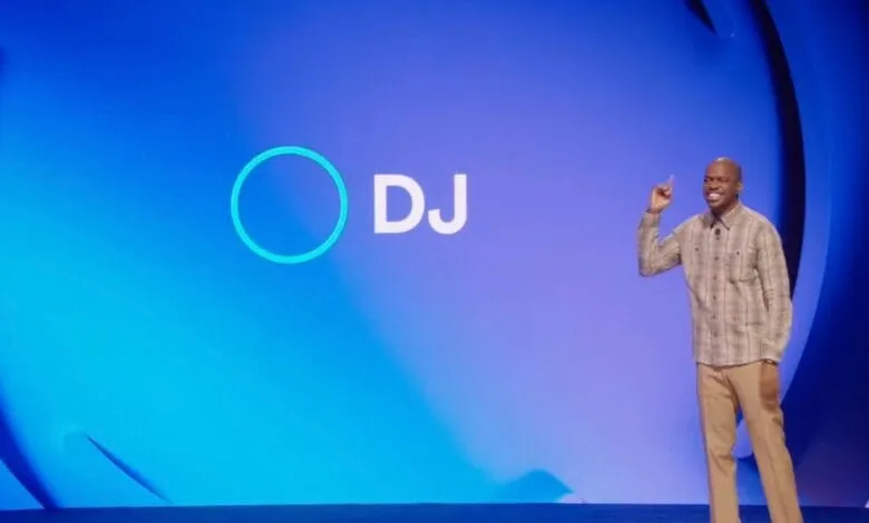 A man on a stage with a blue background that says 'DJ'. He's smiling and gesturing with his hand.
