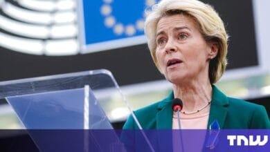 Ursula von der Leyen, President of the European Commission, speaks at a podium, wearing a teal jacket and a pearl necklace.