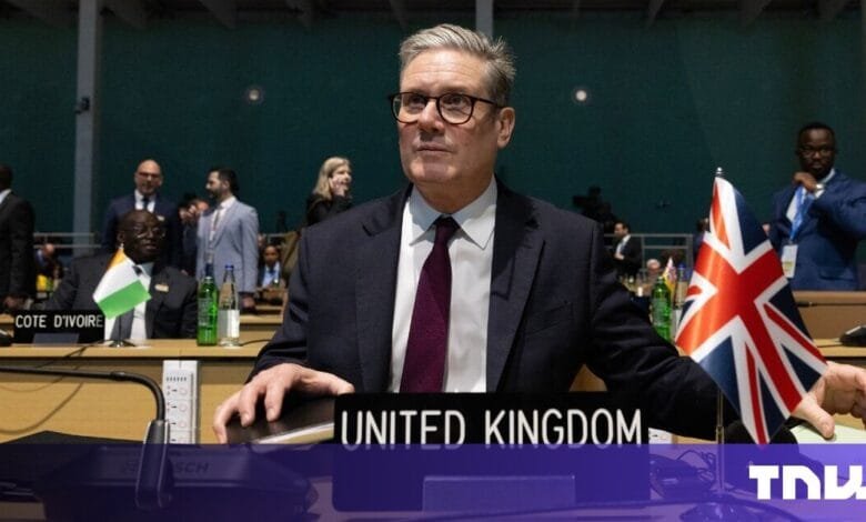 Rishi Sunak, UK Prime Minister, sits at an international conference table, the Union Jack visible nearby.
