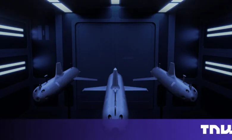 Three futuristic submarines in a dark, metallic hangar, illuminated by bright blue lights.