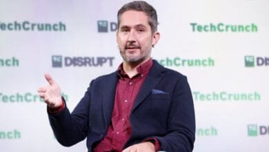 Kevin Systrom, Instagram co-founder, speaks at TechCrunch Disrupt, gesturing while on stage. Green and white branding is visible.