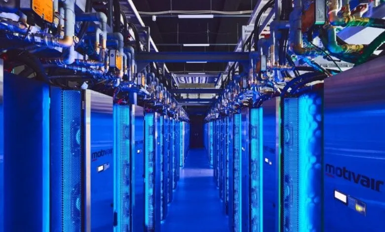 Rows of blue-lit server racks in a data center extend into the distance, showcasing advanced technology and infrastructure.