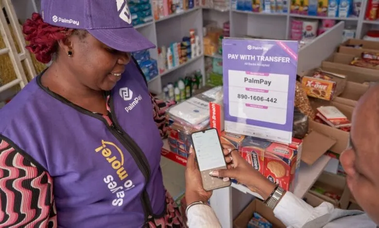 A woman in a purple PalmPay vest uses a mobile phone to make a payment at a store. The transaction is displayed on a PalmPay sign.