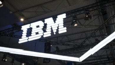 Large illuminated IBM logo hangs from a ceiling structure.