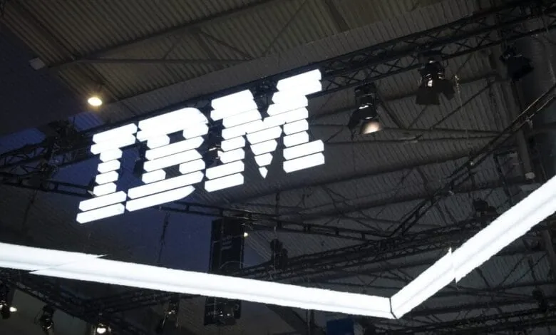 Large illuminated IBM logo hangs from a ceiling structure.