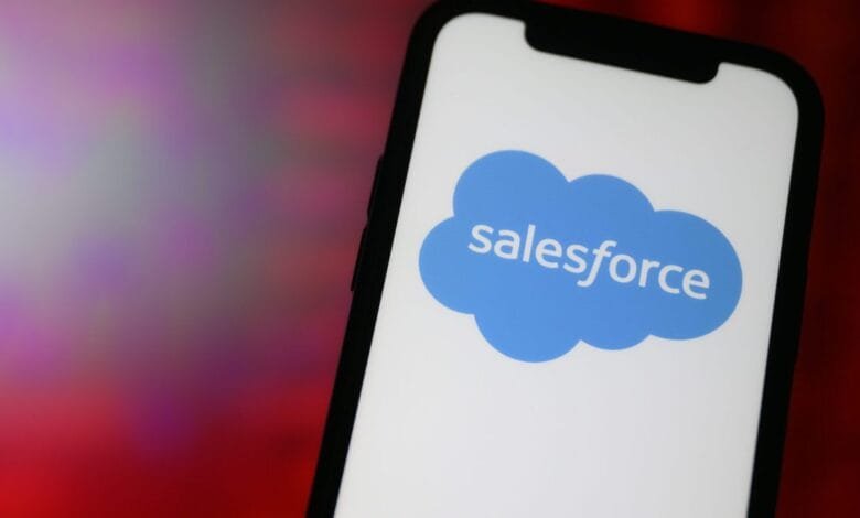 Close-up of a smartphone displaying the Salesforce logo, a blue cloud with the word 'salesforce' inside.
