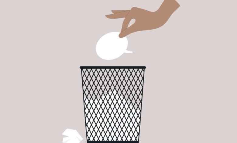 Hand throws speech bubble into trash can; visual metaphor for censorship or silencing of voices.