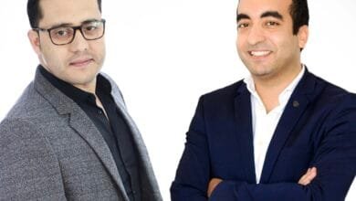Karim Jouini and Jihed Othmani stand against a white background. One wears a gray blazer, the other a navy blazer.