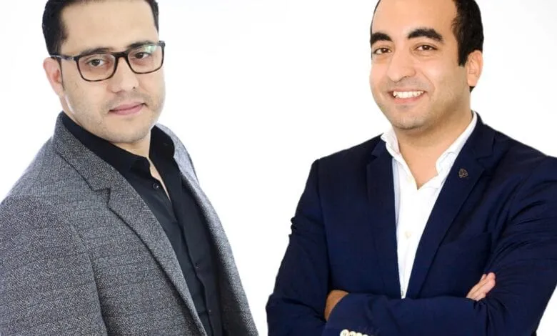 Karim Jouini and Jihed Othmani stand against a white background. One wears a gray blazer, the other a navy blazer.