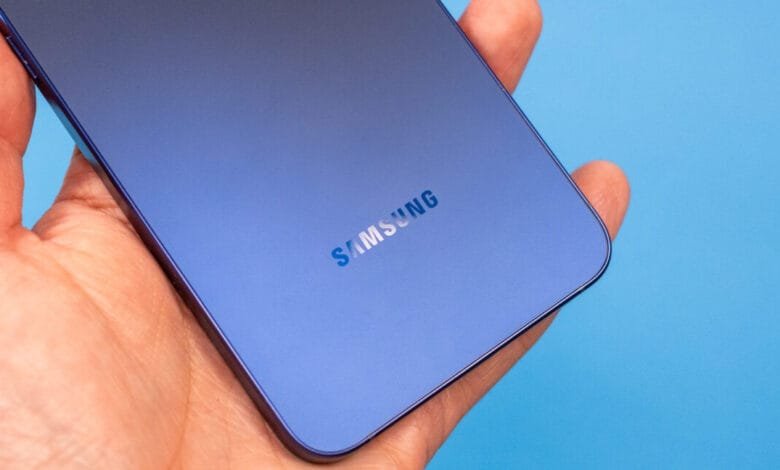 Close-up of a hand holding a Samsung phone, showcasing the subtle Samsung logo on the back.