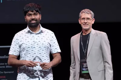 Cyril Gorlla founder of CTGT, stand on stage, holding VB Transform25 award award. They appear at a technology conference.