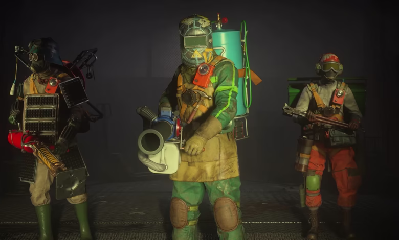 Three figures in hazmat suits and unique weaponry stand in a dimly lit industrial setting.