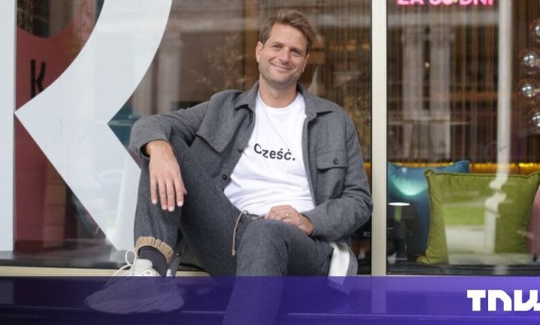 Sebastian Siemiatkowski, Klarna’s CEO, sits casually on a windowsill, wearing a gray jacket and white t-shirt with Polish writing. He smiles at the camera.