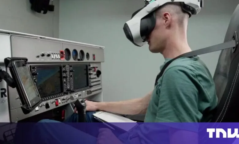 Person wearing a VR headset sits in a flight simulator, hands on controls and tablet.