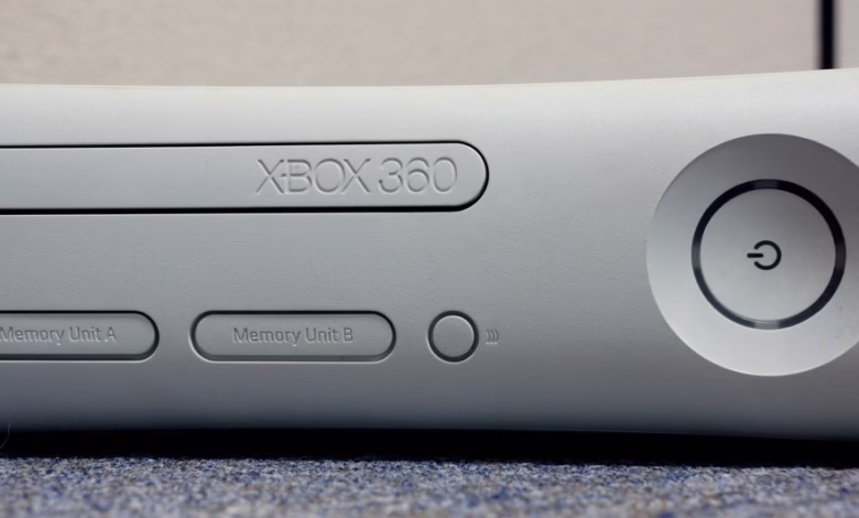Close-up of a white Xbox 360 console, showing its power button and memory unit slots.
