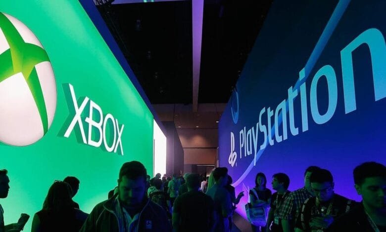 Large Xbox and PlayStation displays at a gaming convention, with attendees walking between them.